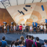 Climbers and routesetters in front of the natural wood boulder during Set & Send Boulder Comp in Sofia, Bulgaria